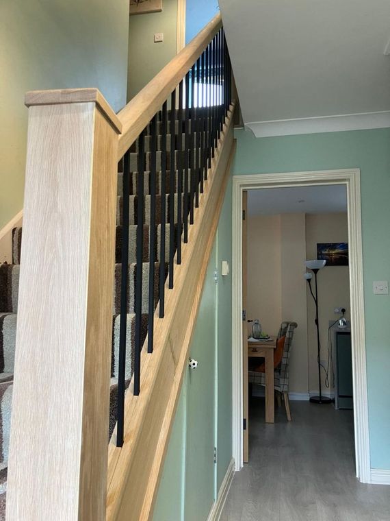 Oak handrail and black metal spindles fitted over an existing staircase