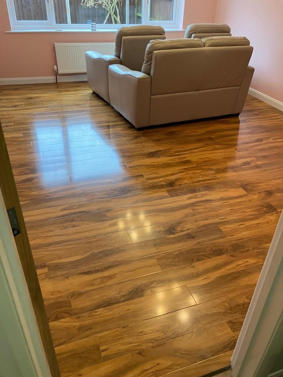Engineered walnut flooring laid across a living room with sofas back in place