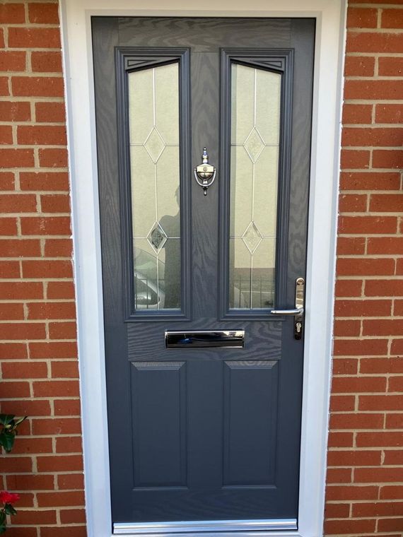 Anthracite composite front door with leaded glass and chrome furniture, fitted into a brick opening