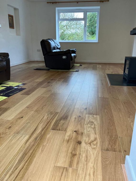 Engineered oak flooring laid across a living room with a log burner
