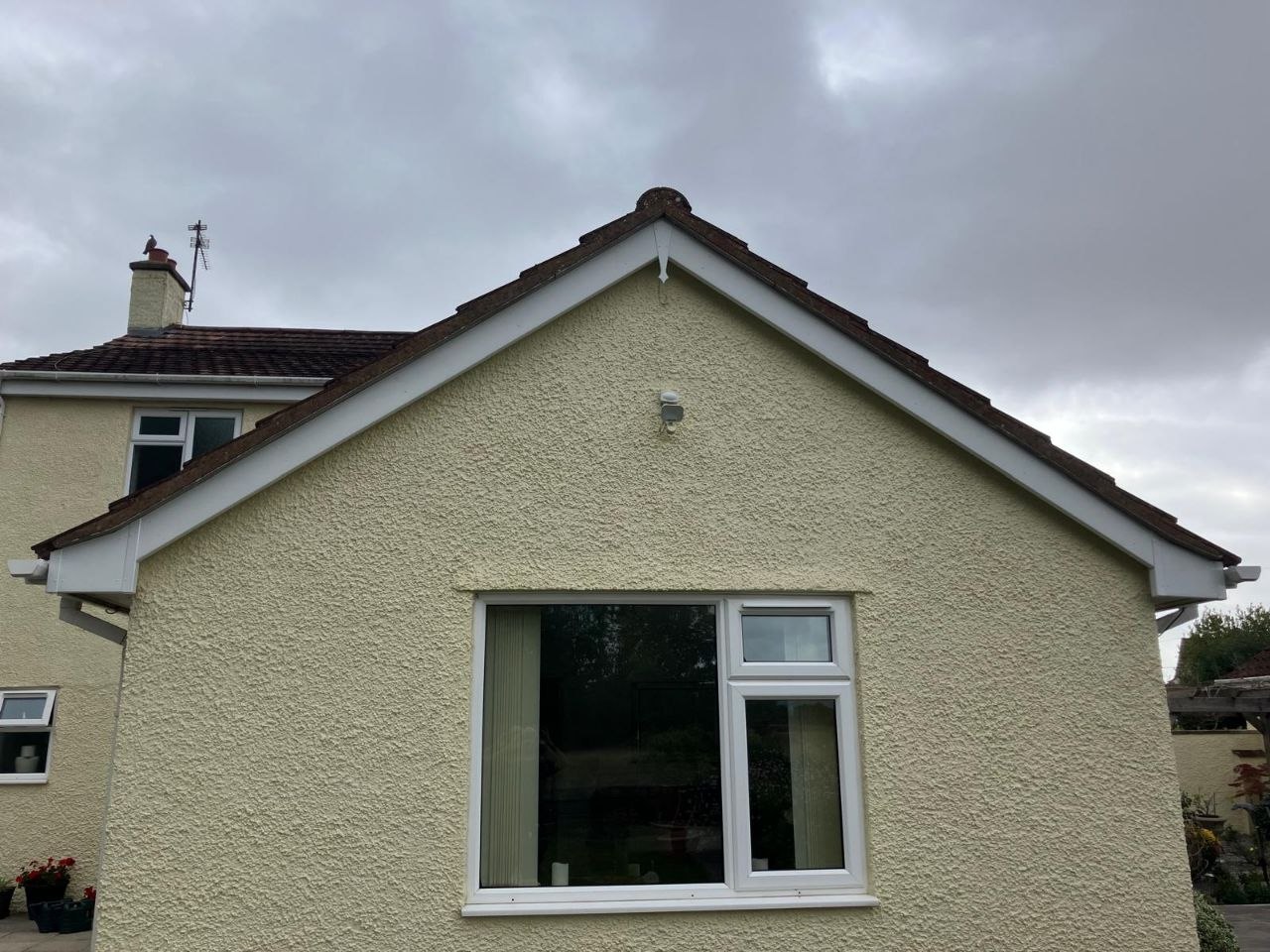 Rendered gable end with newly fitted white fascia boards running along both roof verges, and white guttering