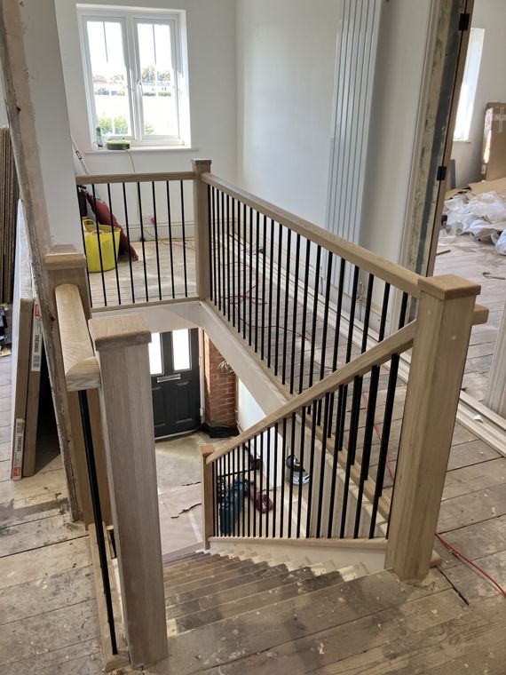 Oak handrail and black metal spindles fitted over an existing staircase